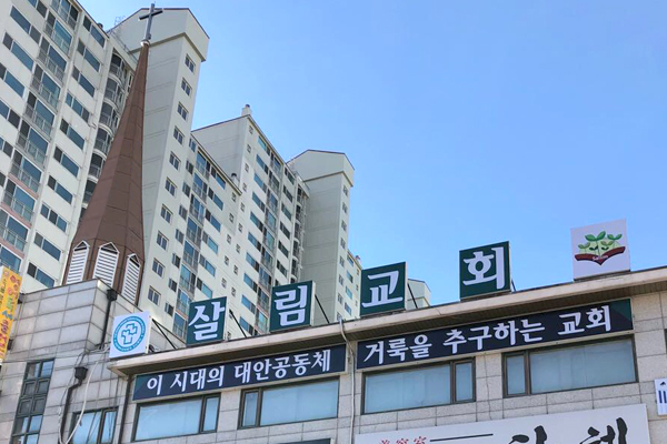 건물 위에 걸린 살림교회 간판을 길에서 올려다본 모습